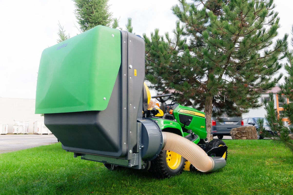 John Deere X948 mit dem Materialaufnahmegerät von matev für Traktoren in der Kommunaltechnik.