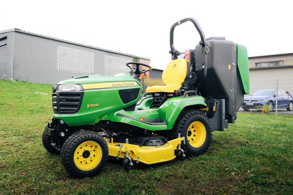 John Deere X948 mit dem Materialaufnahmegerät von matev für Traktoren in der Kommunaltechnik.