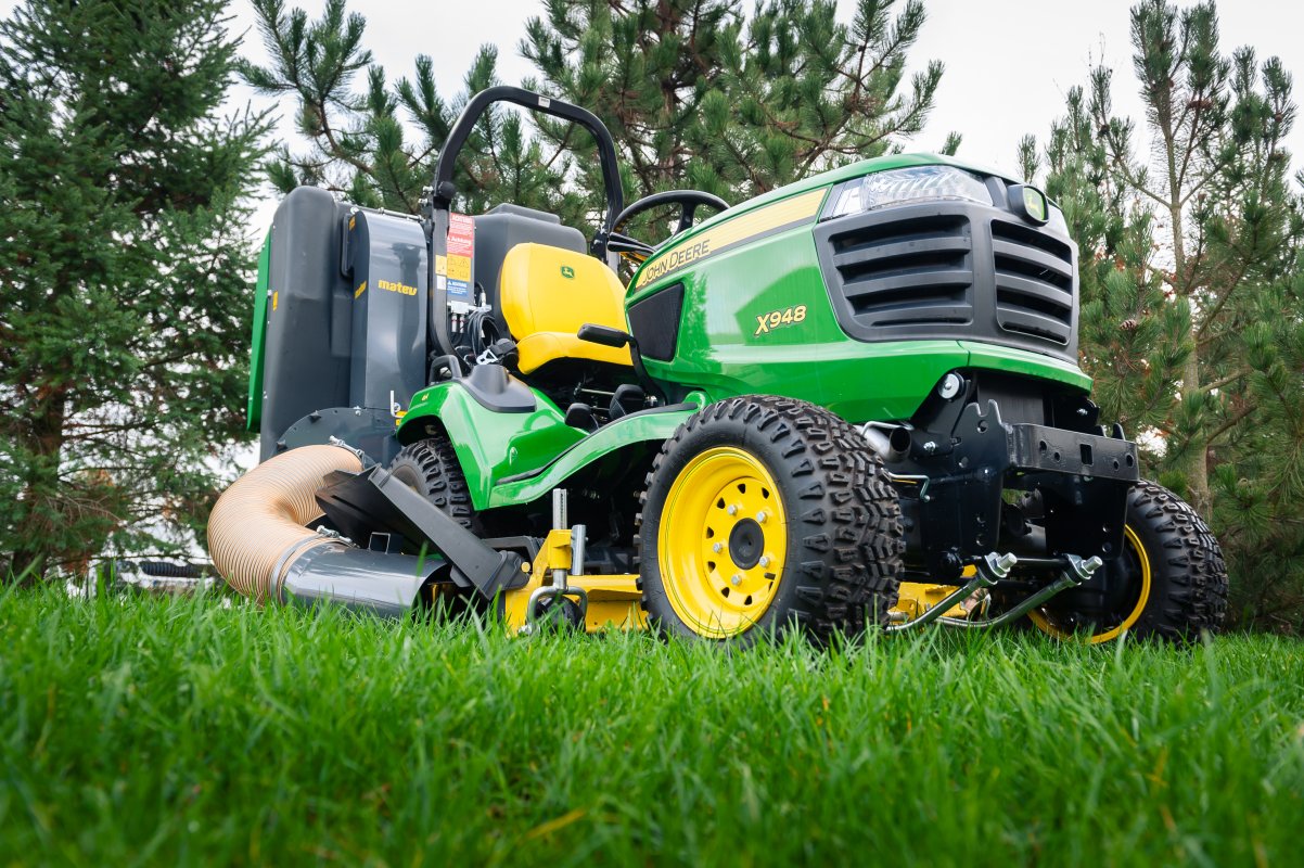 John Deere X948 mit dem Materialaufnahmegerät von matev für Traktoren in der Kommunaltechnik.